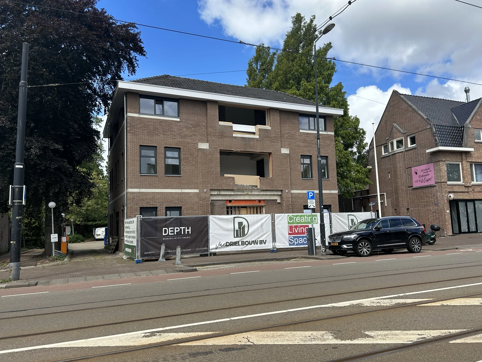 Renovatie van een bakstenen pand aan de Bergse Dorpsstraat, met bouwhekken en een geparkeerde auto op de voorgrond.